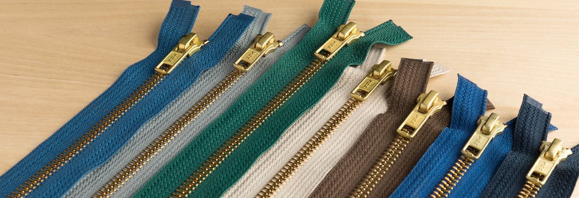 Brass Jacket Zippers on Wooden Work Table in Different Colors