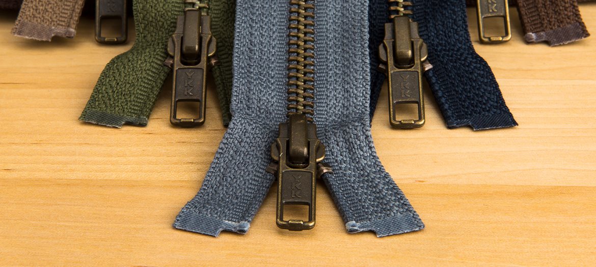 Antique Brass Jacket Zippers in a variety of colors on display on table